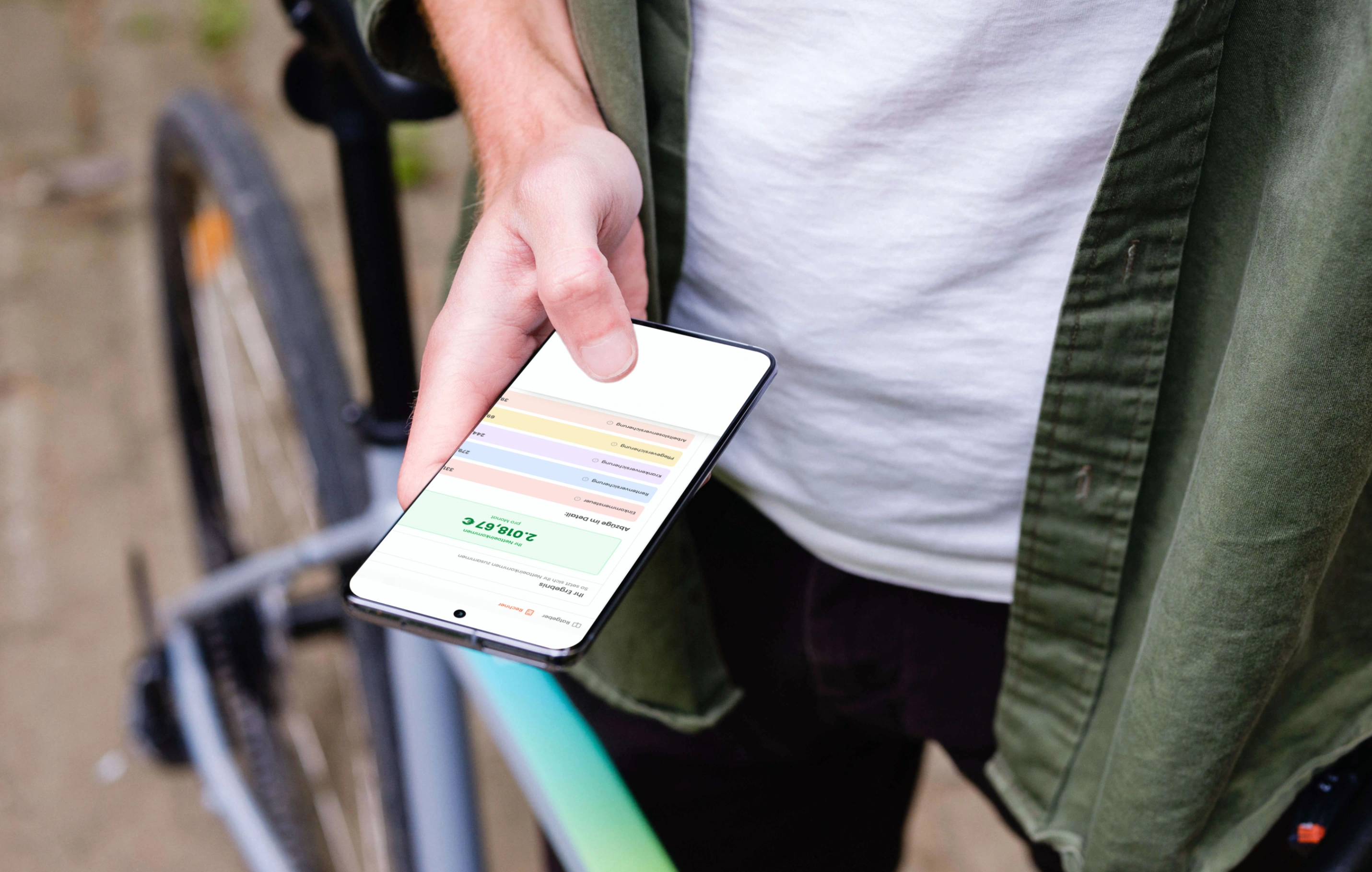 Person hält Smartphone neben Fahrrad und nutzt Brutto-Netto-Gehaltsrechner-App.