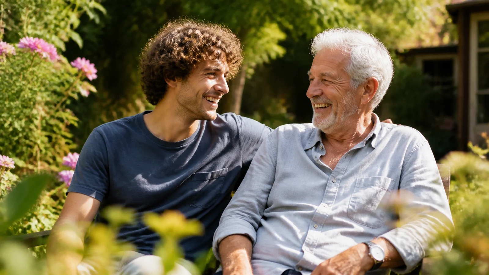 Junger Erwachsener und älterer Erwachsener lachen gemeinsam im sonnigen Garten